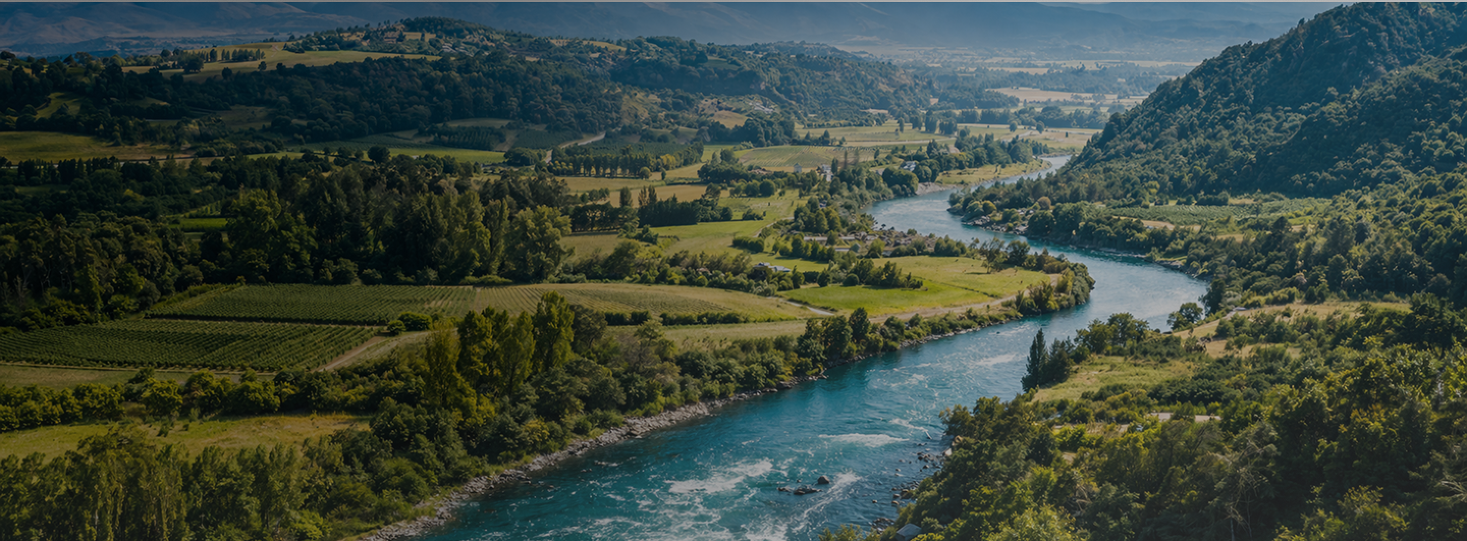 Valle chileno con río y cultivos, representando la gestión de recursos hídricos